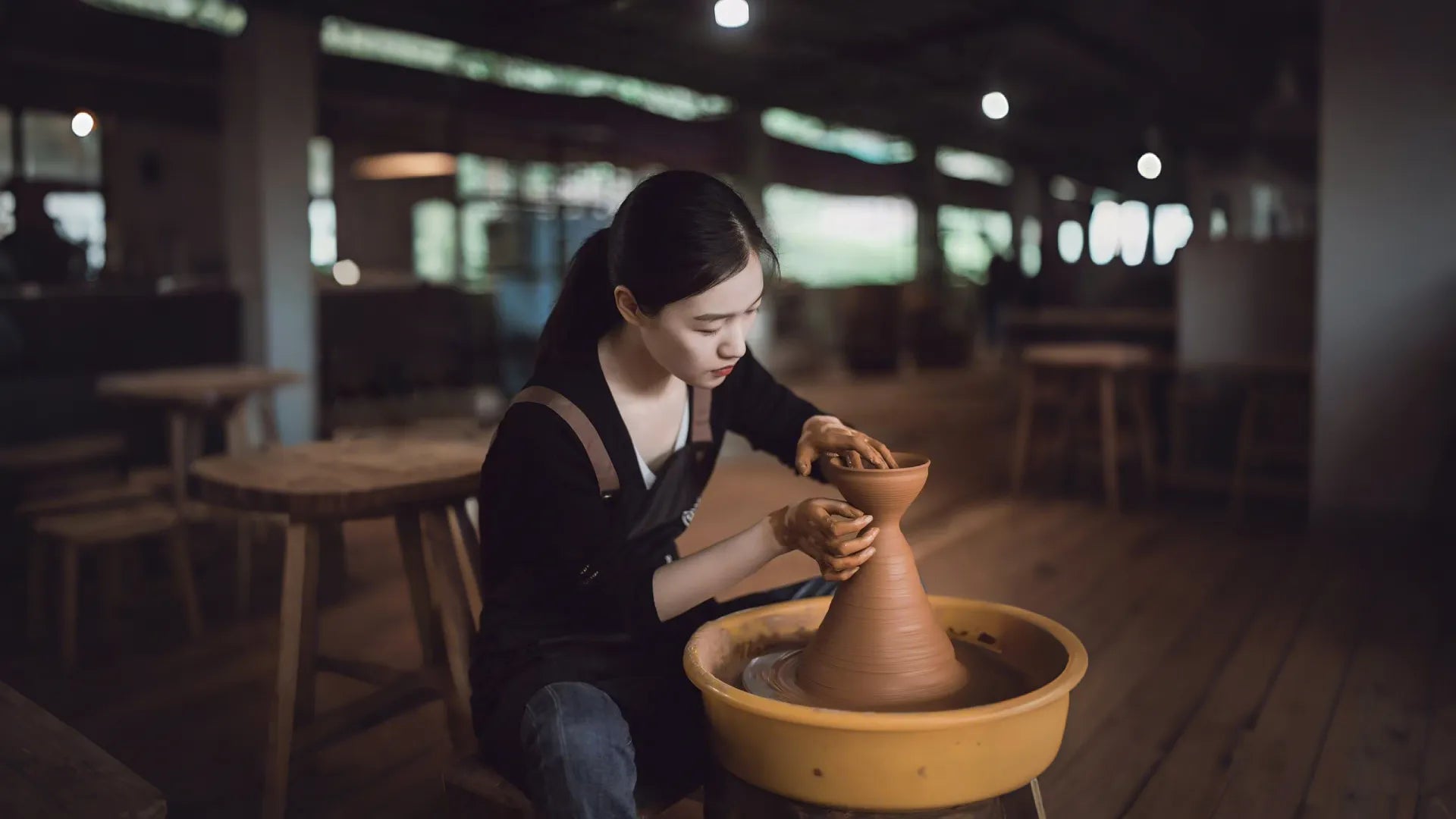 Handcrafted porcelain process in Jingdezhen: A master artisan meticulously molding raw clay on a pottery wheel. Capturing the authentic 72-step traditional ceramic craftsmanship of high-fire porcelain.