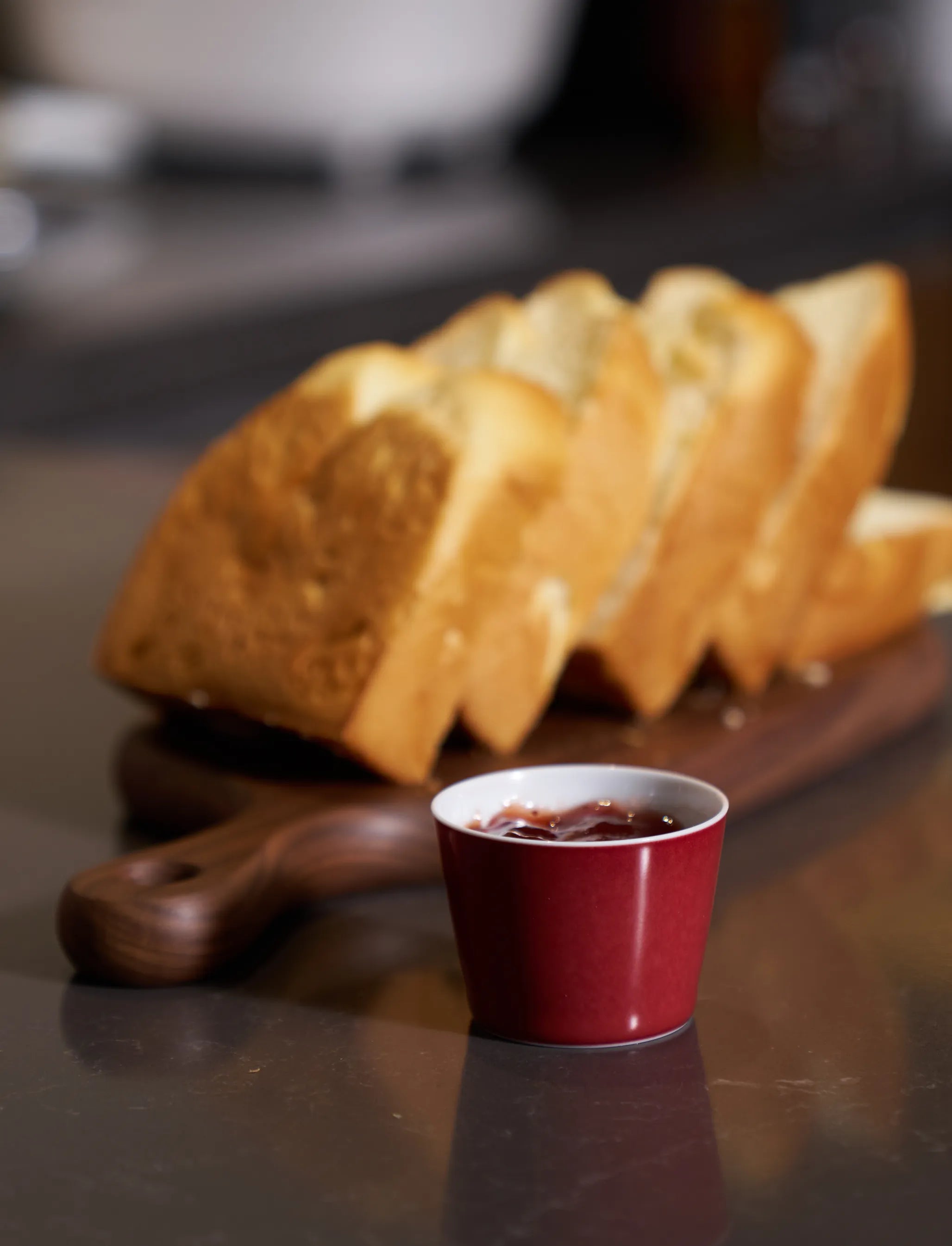 2.7oz SaraGaia red cup on a breakfast table with toast. Elegant morning ritual.