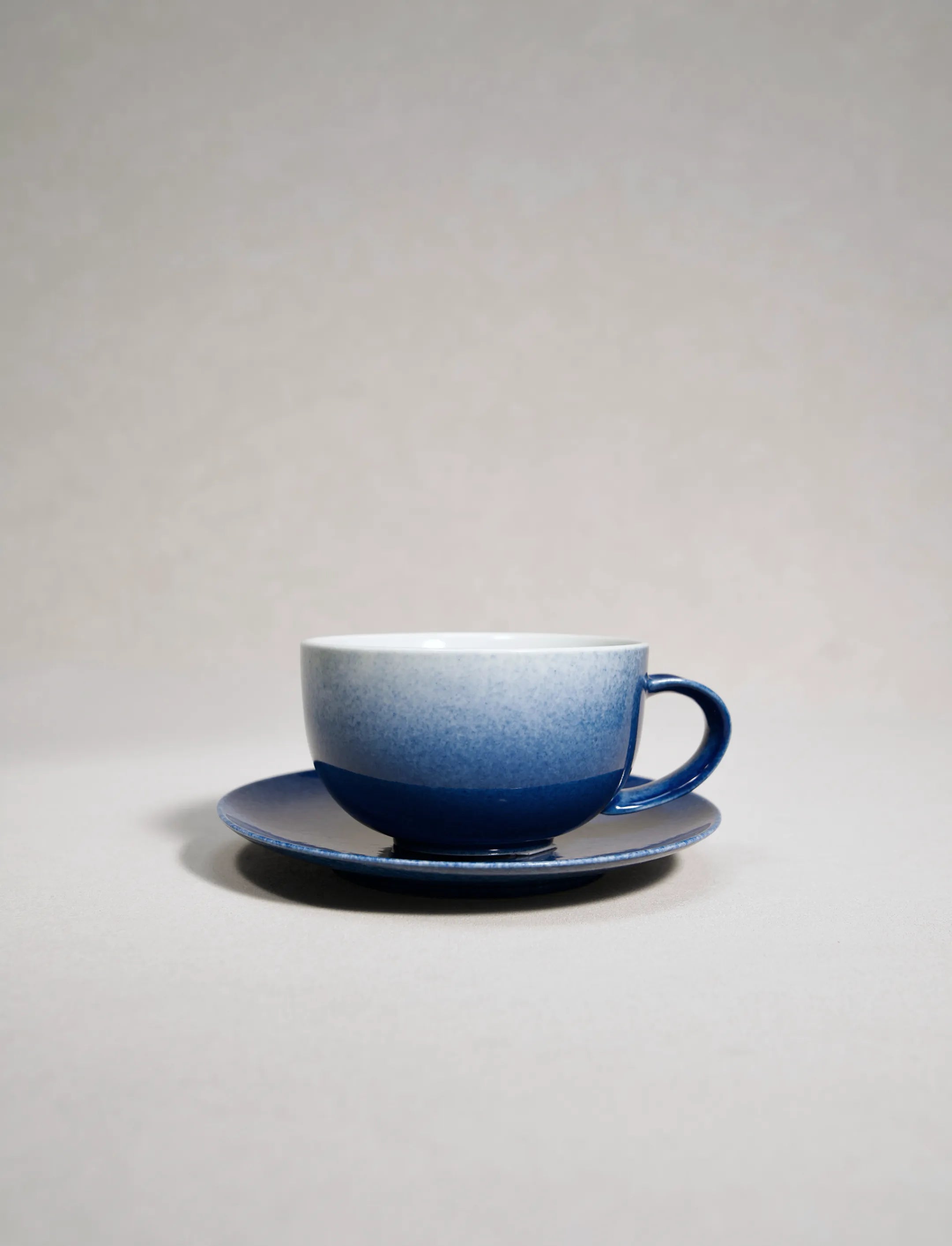 SaraGaia luxury porcelain latte cup with saucer, featuring a sprinkling blue snowflake glaze.