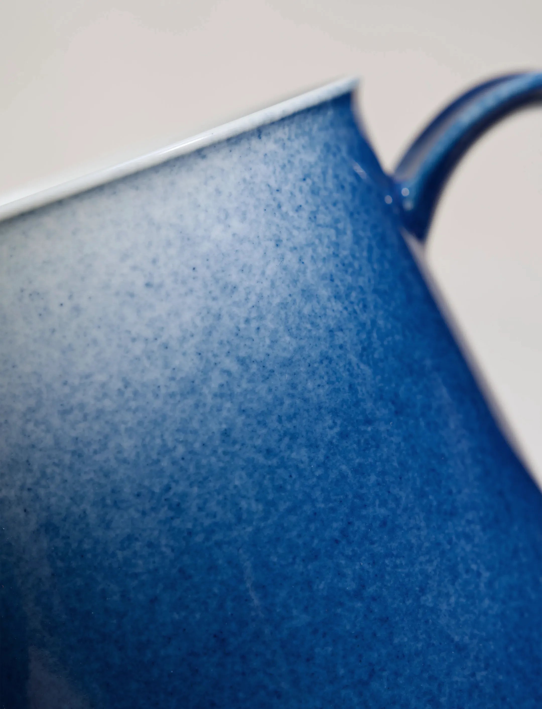 Close-up of SaraGaia artisan porcelain cup, revealing the gradient sprinkling blue glaze texture.