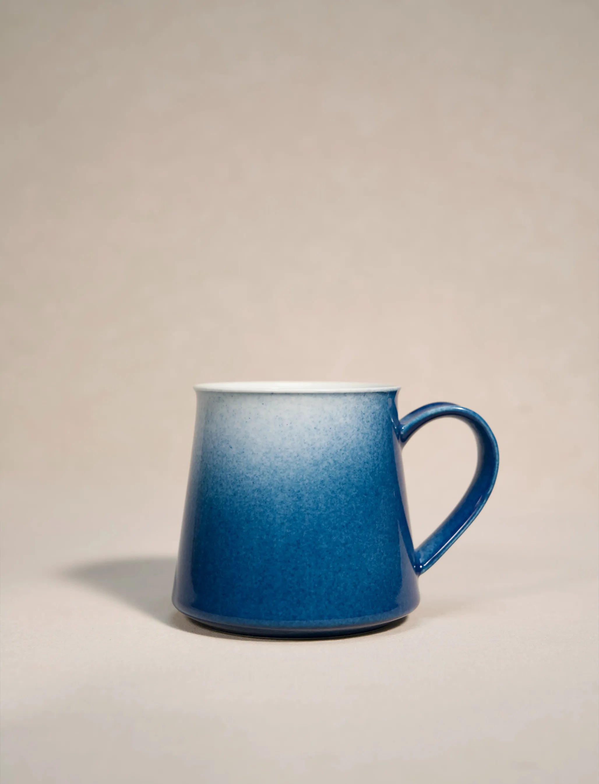 SaraGaia artisan porcelain mug featuring a gradient sprinkling blue snowflake glaze effect.