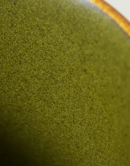 A close-up detail shot highlighting the micro-crystalline texture and natural olive-green hue of Saragaia's signature tea-dust glaze on ceramic.