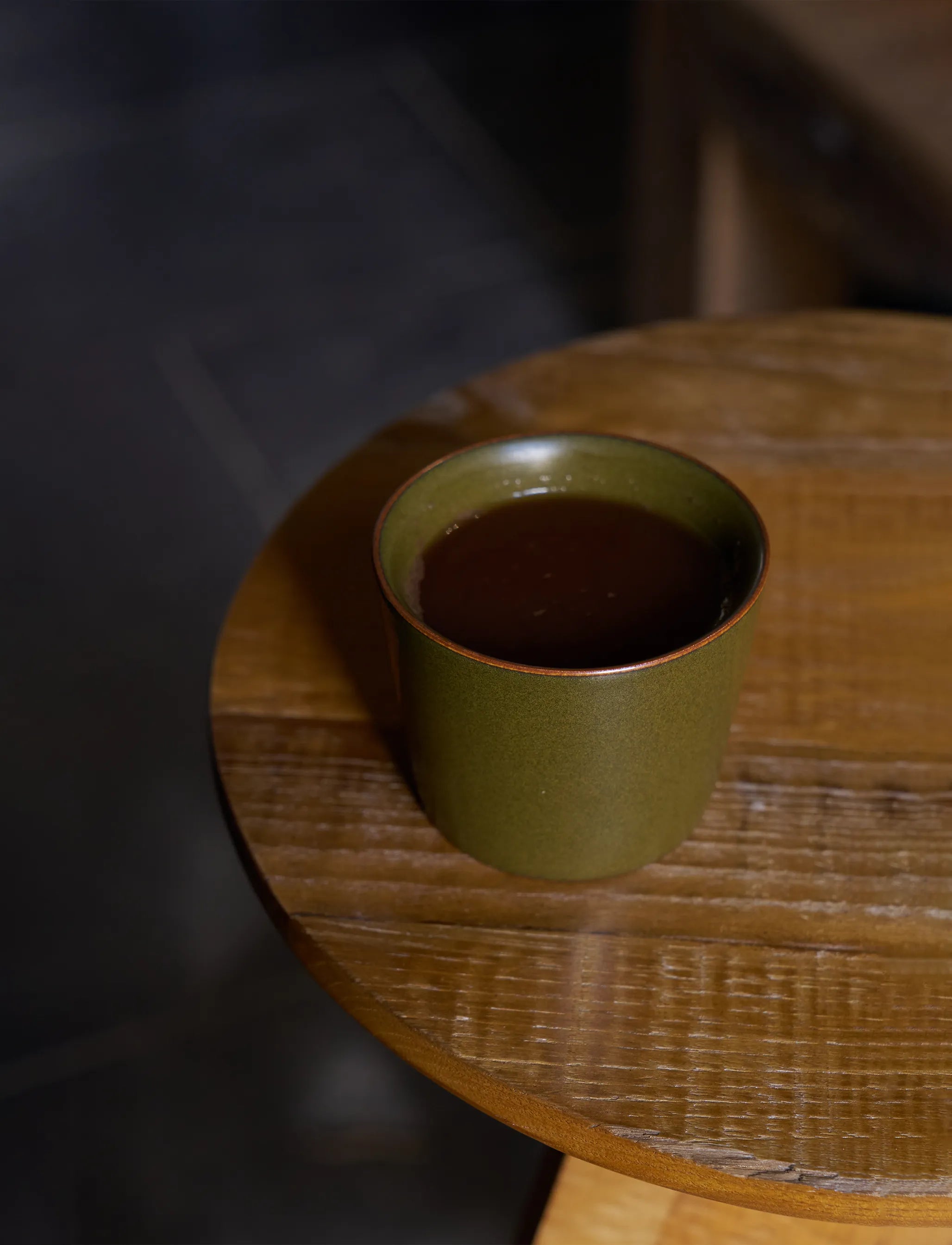 6.8oz SaraGaia cup on a rustic wood table. Elegant lifestyle tea ritual.