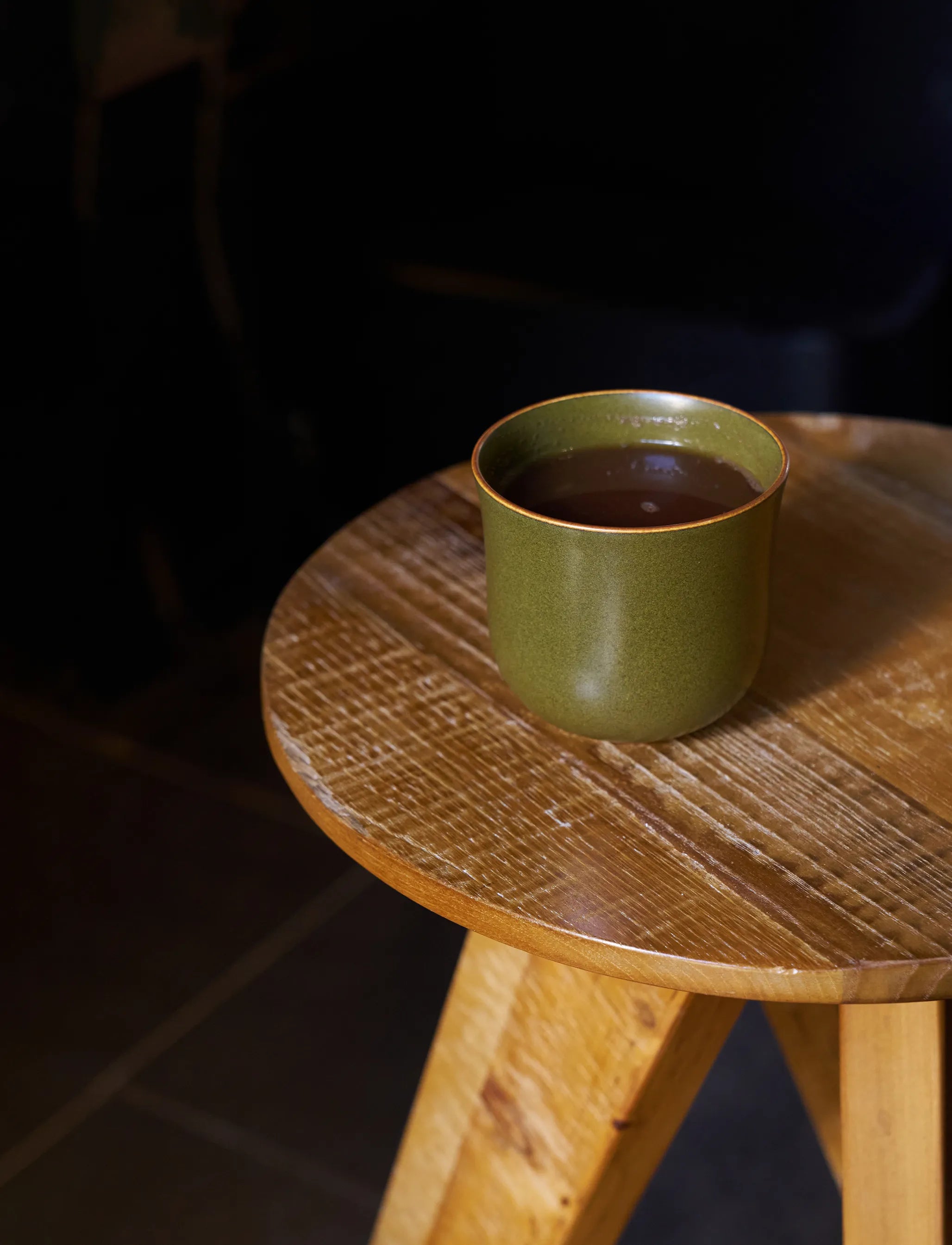 SaraGaia bell cup on a rustic wood stool. Elegant tea ceremony detail.