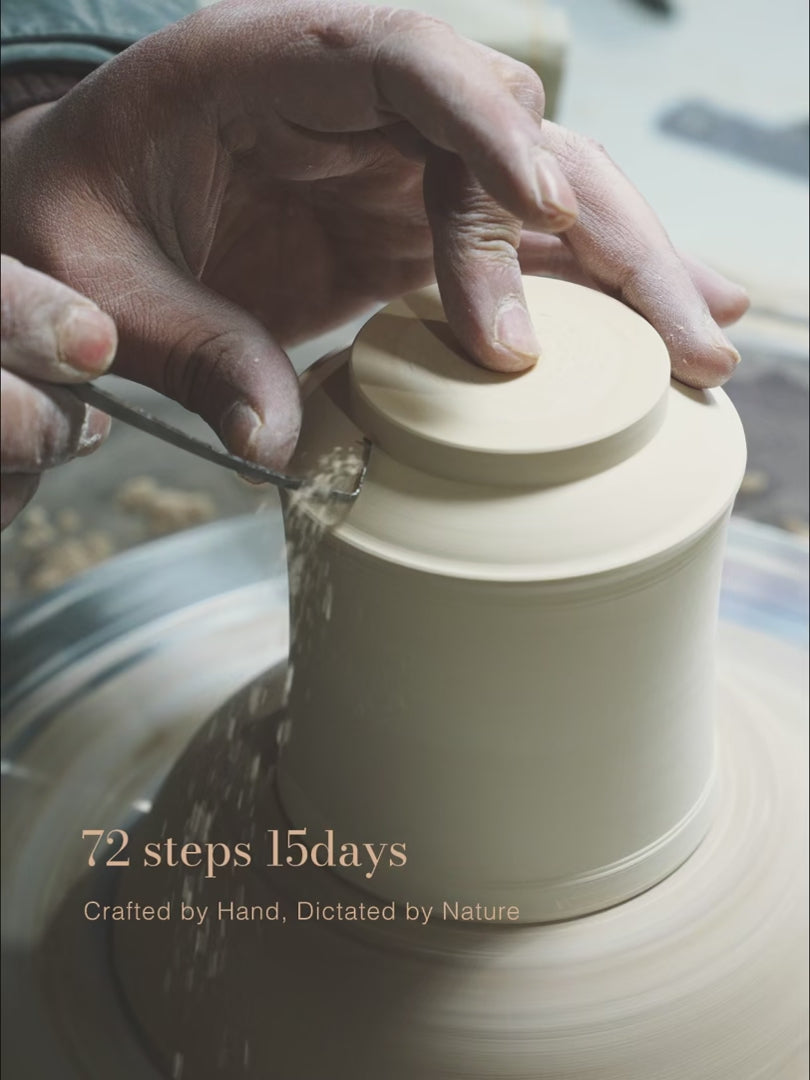 A close-up video of the meticulous hand-trimming process on a pottery wheel, a key part of the 72-step handcrafted journey for a SaraGaia Jingdezhen porcelain cup. This 15-day artisanal creation process ensures each piece achieves its unique, nature-dictated bamboo form.