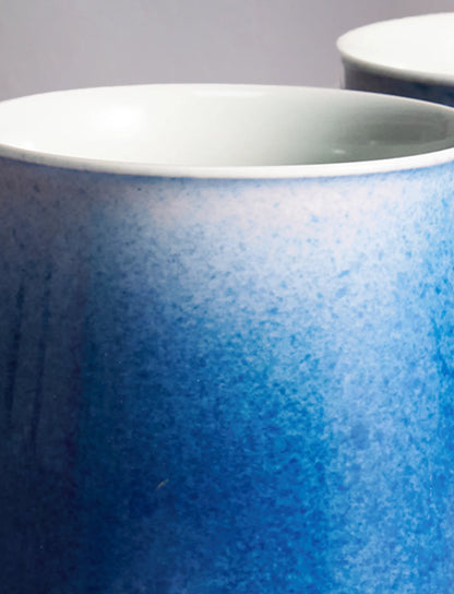 Close-up of SaraGaia artisan porcelain cup, revealing the gradient sprinkling blue glaze texture.