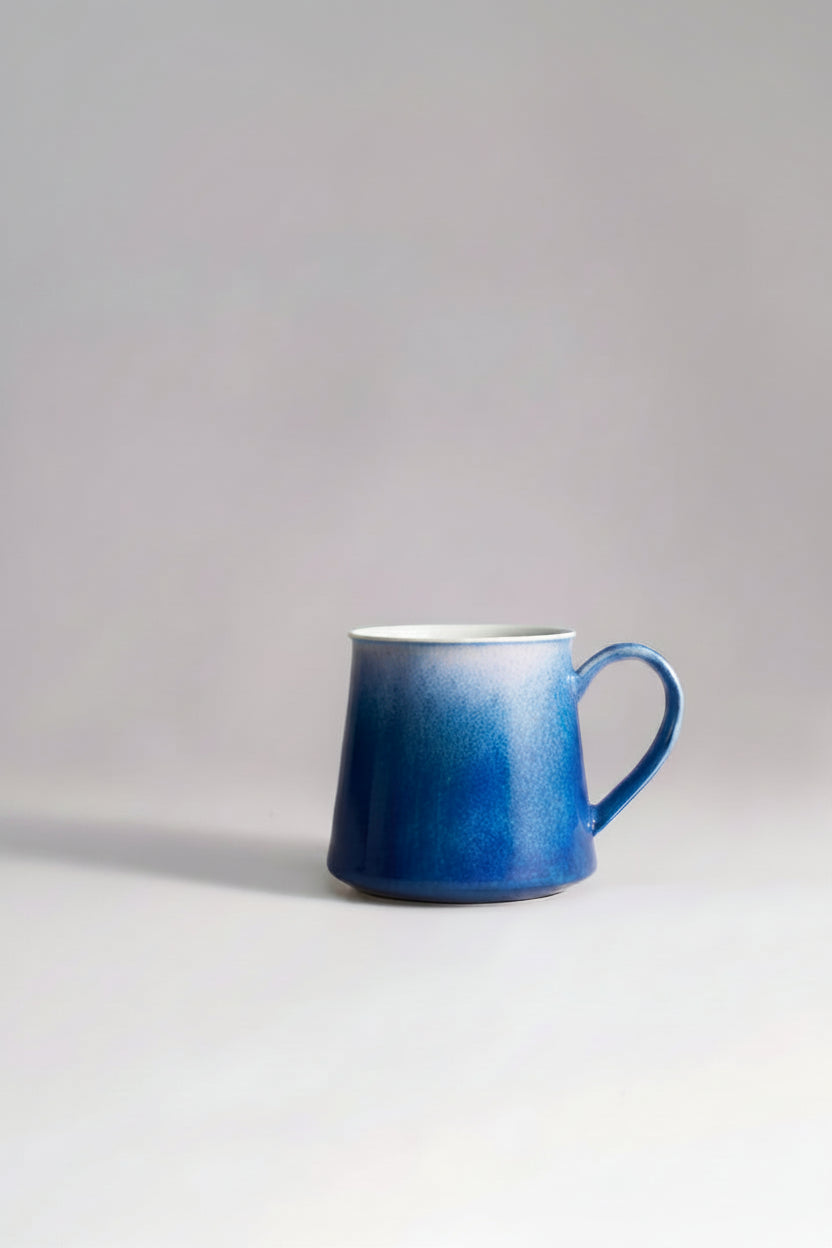 SaraGaia artisan porcelain mug featuring a gradient sprinkling blue snowflake glaze effect.