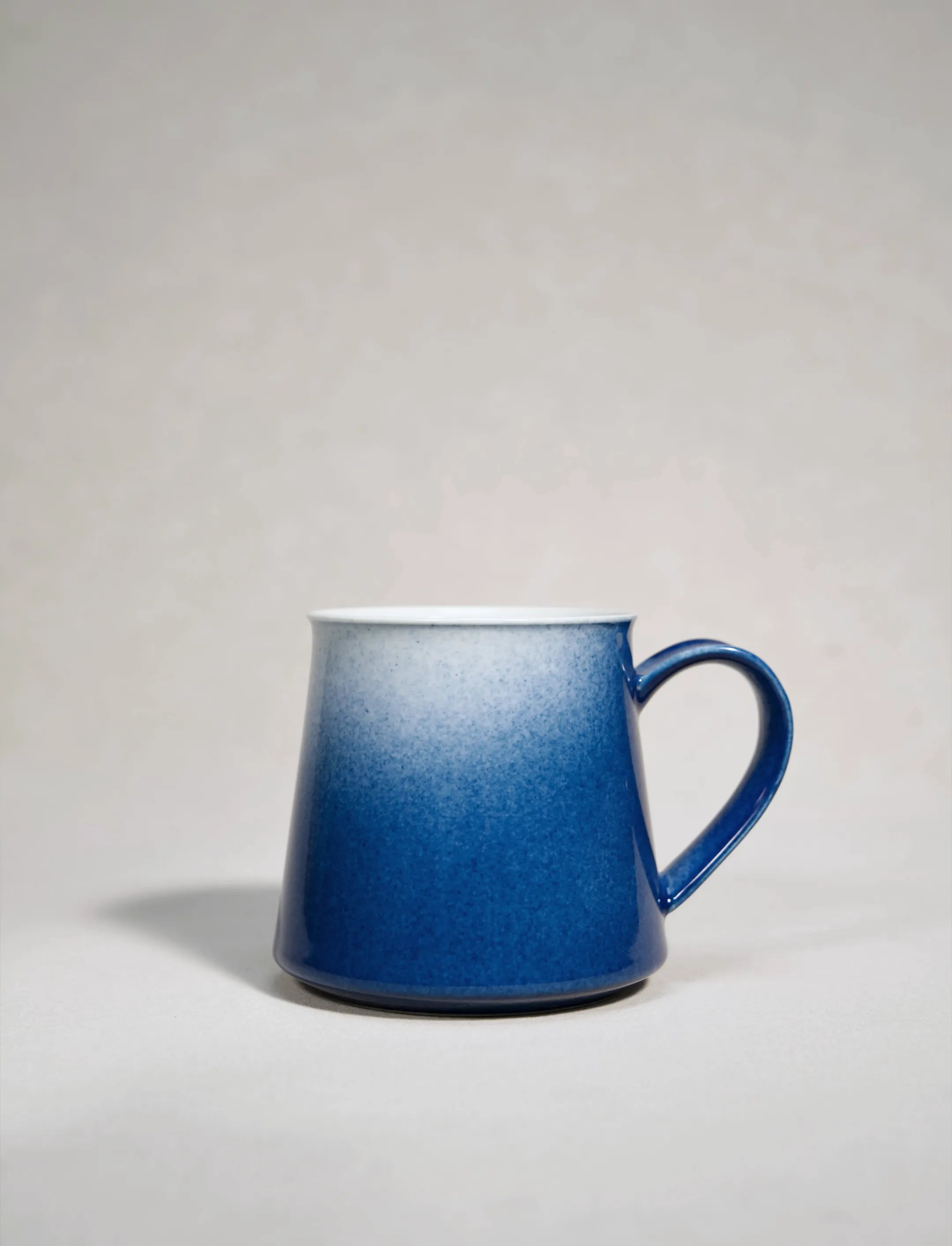SaraGaia artisan porcelain mug featuring a gradient sprinkling blue snowflake glaze effect.