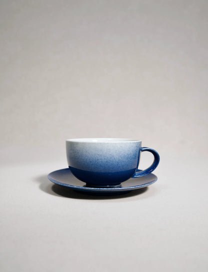SaraGaia luxury porcelain latte cup with saucer, featuring a sprinkling blue snowflake glaze.