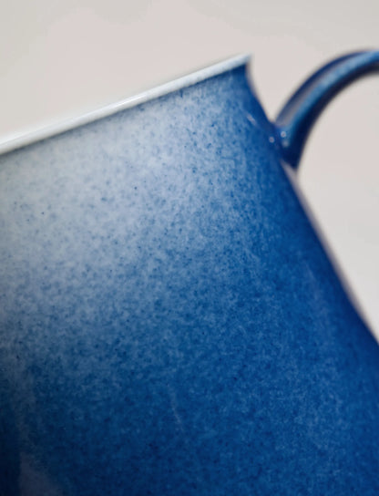 Close-up of SaraGaia artisan porcelain cup, revealing the gradient sprinkling blue glaze texture.
