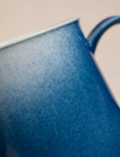 Close-up of SaraGaia artisan porcelain cup, revealing the gradient sprinkling blue glaze texture.