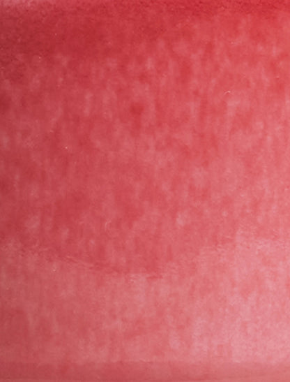 Close-up of SaraGaia porcelain cup showcasing mottled crimson tones of copper peach bloom glaze.